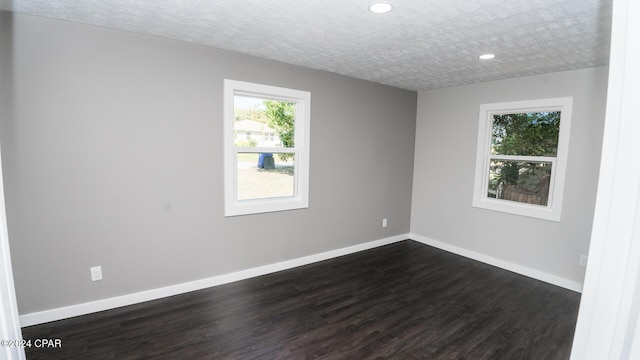 unfurnished room featuring recessed lighting, baseboards, a healthy amount of sunlight, and dark wood-type flooring