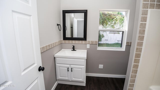 bathroom featuring vanity, baseboards, and wood finished floors
