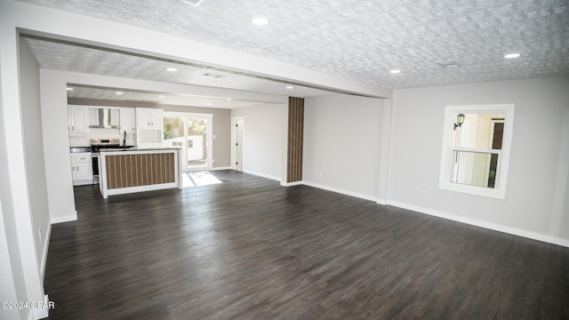 unfurnished living room featuring beam ceiling, a textured ceiling, and dark hardwood / wood-style floors