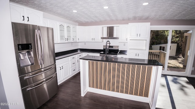 kitchen with wall chimney range hood, stainless steel fridge with ice dispenser, dark countertops, and a sink