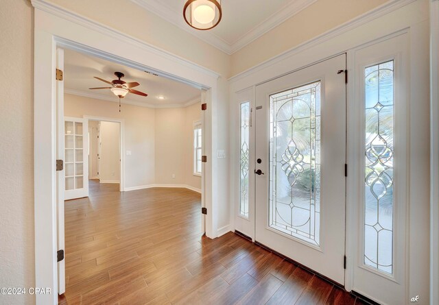 entrance foyer with crown molding, wood-type flooring, and ceiling fan