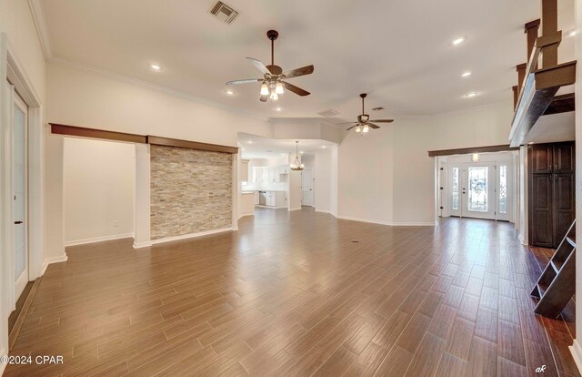 unfurnished living room featuring crown molding, hardwood / wood-style flooring, and ceiling fan with notable chandelier