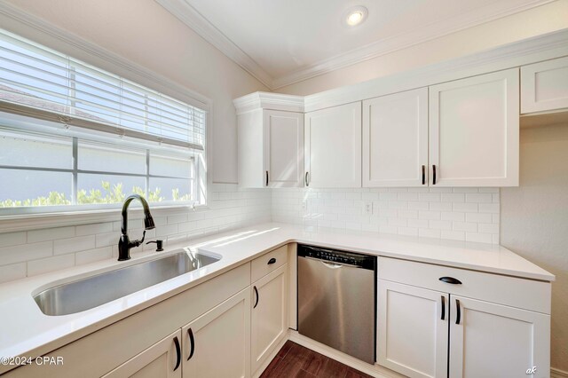 kitchen with backsplash, dark hardwood / wood-style flooring, stainless steel dishwasher, ornamental molding, and sink