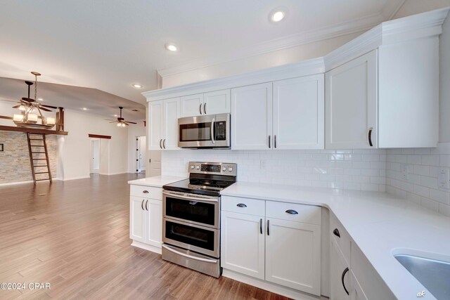 kitchen featuring ornamental molding, white cabinets, stainless steel appliances, and light hardwood / wood-style floors