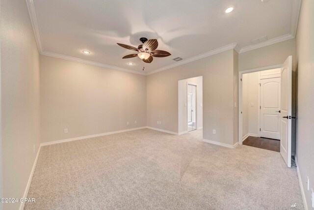 carpeted spare room with crown molding and ceiling fan