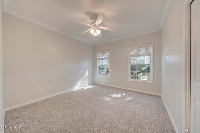 spare room with crown molding, light colored carpet, and ceiling fan