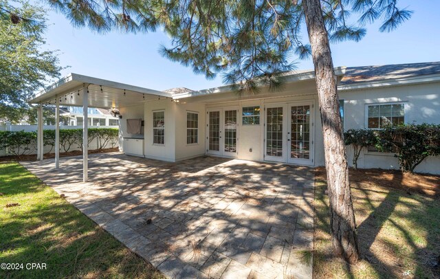 rear view of house featuring french doors and a carport