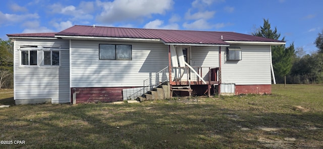 back of house featuring metal roof and a yard