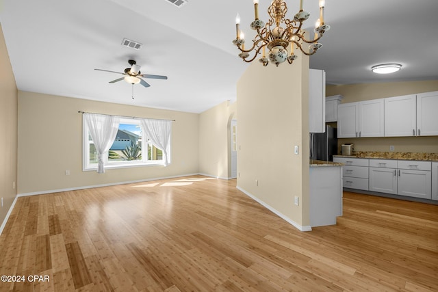 unfurnished living room featuring vaulted ceiling, light hardwood / wood-style flooring, and ceiling fan with notable chandelier