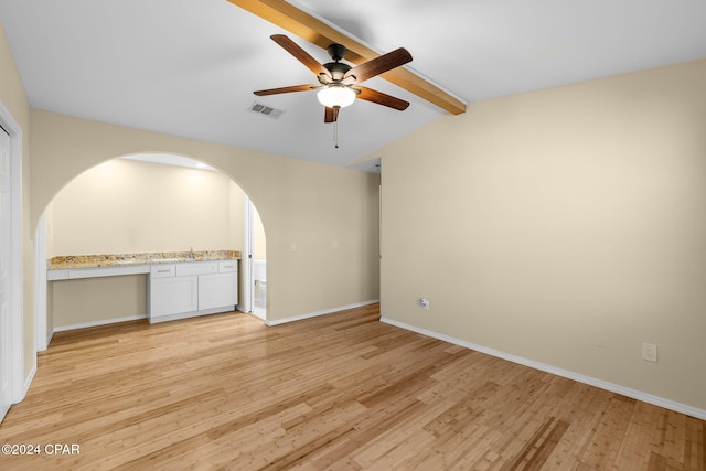 interior space with built in desk, lofted ceiling with beams, light hardwood / wood-style floors, and ceiling fan