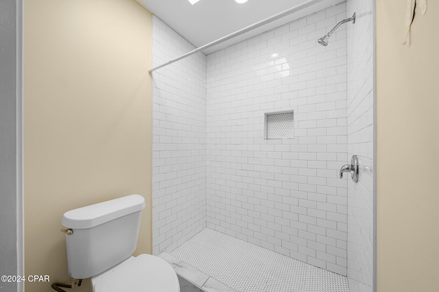 bathroom featuring toilet and a tile shower