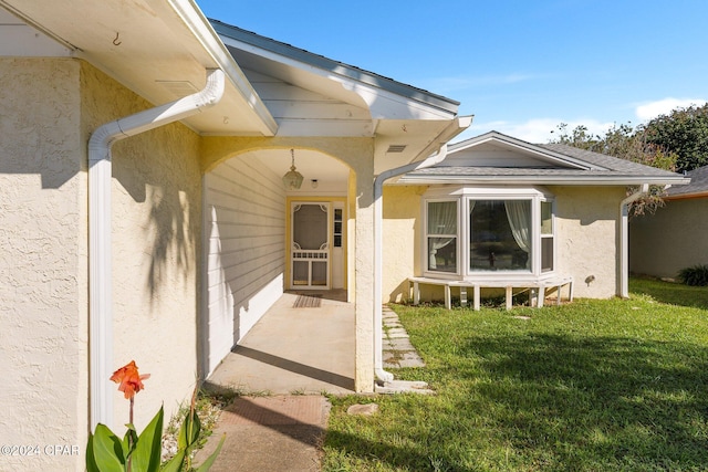 property entrance featuring a lawn