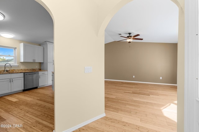 kitchen featuring light hardwood / wood-style floors, lofted ceiling, dishwasher, and white cabinets