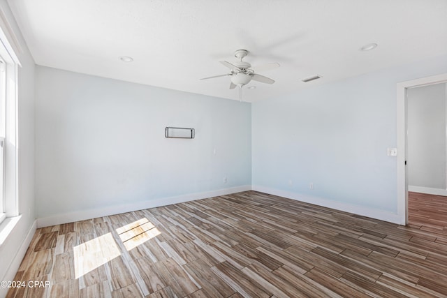 empty room with hardwood / wood-style floors and ceiling fan