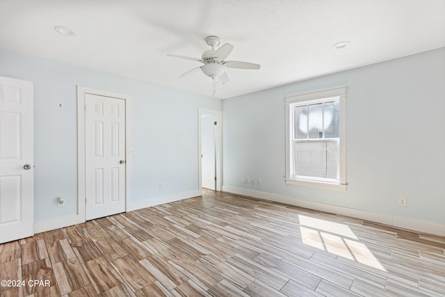 empty room with light wood-type flooring and ceiling fan