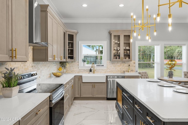 kitchen with wall chimney range hood, stainless steel appliances, sink, crown molding, and pendant lighting