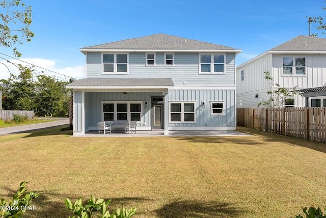 rear view of property with a patio area, a yard, and ceiling fan