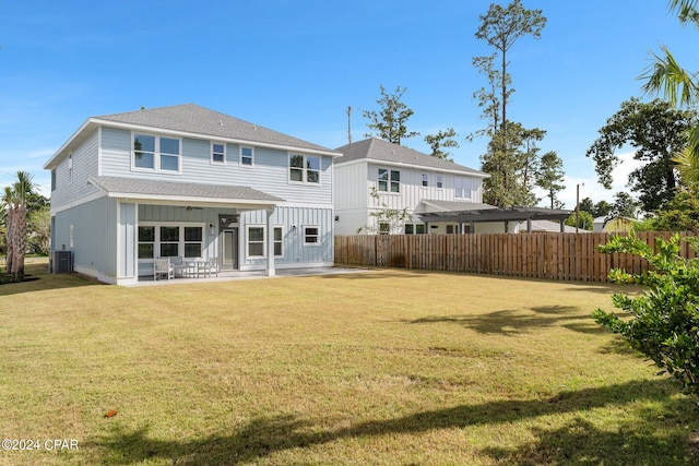 rear view of property featuring a yard, cooling unit, and a patio