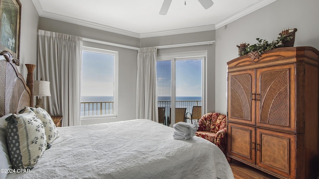 bedroom with a water view, access to outside, multiple windows, and ornamental molding