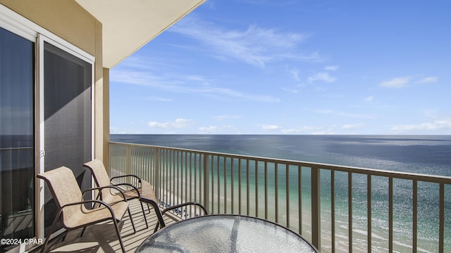 balcony featuring outdoor dining space and a water view