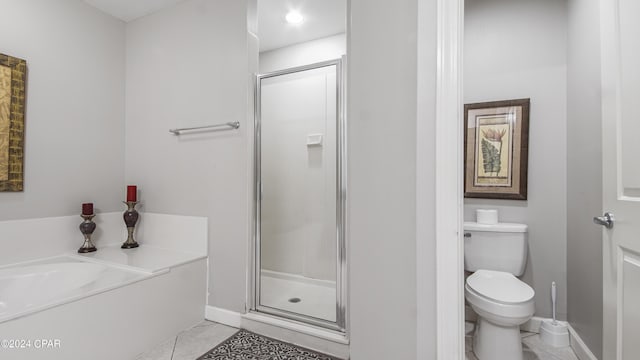 bathroom with toilet, a stall shower, tile patterned flooring, and baseboards