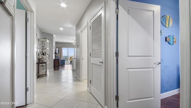 hallway featuring light tile patterned floors, recessed lighting, and baseboards