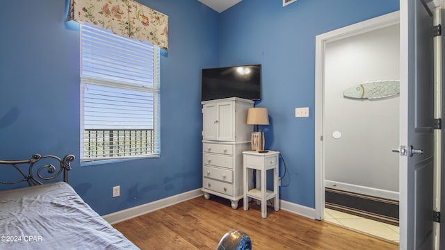 bedroom featuring wood finished floors and baseboards