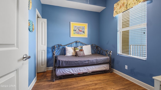 bedroom with baseboards and wood finished floors