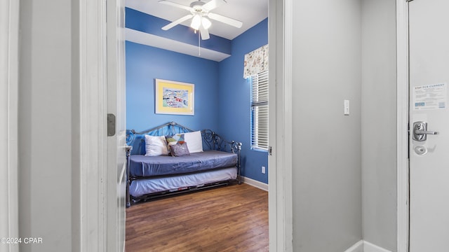 bedroom featuring ceiling fan, baseboards, and wood finished floors