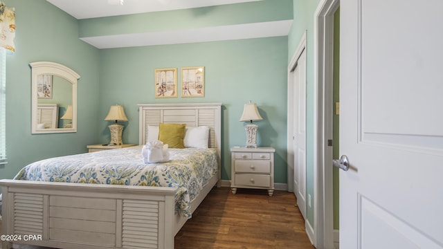 bedroom featuring a closet, baseboards, and dark wood-type flooring