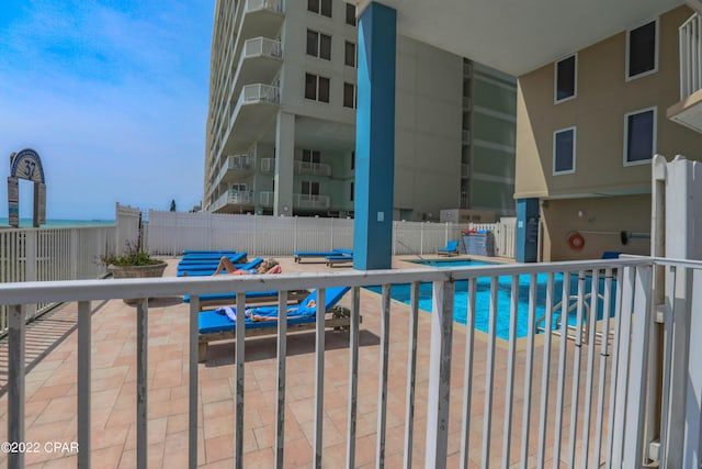 community pool with fence and a patio