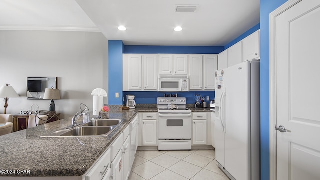 kitchen with white appliances, white cabinets, a peninsula, a sink, and light tile patterned flooring