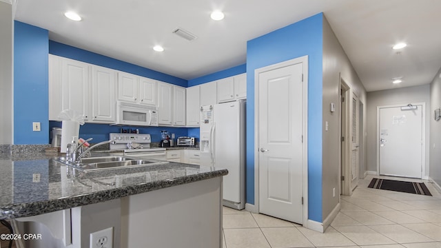 kitchen with white appliances, visible vents, a peninsula, a sink, and light tile patterned flooring