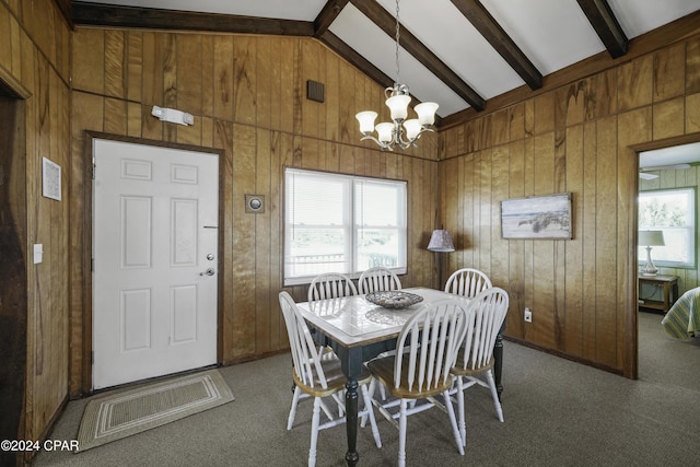 carpeted dining space featuring a wealth of natural light, lofted ceiling with beams, and wood walls