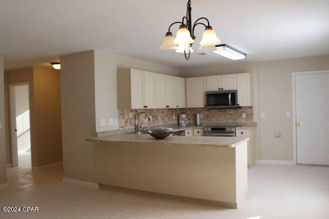 kitchen with appliances with stainless steel finishes, decorative light fixtures, kitchen peninsula, and an inviting chandelier