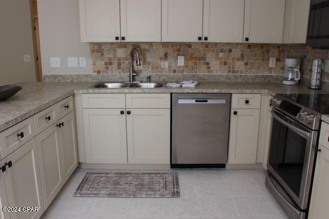 kitchen featuring light tile patterned flooring, appliances with stainless steel finishes, sink, and white cabinets