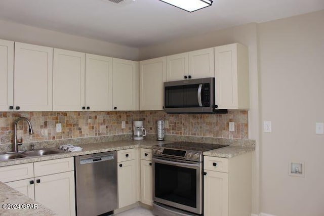 kitchen featuring appliances with stainless steel finishes, white cabinetry, and sink