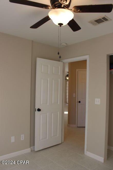 unfurnished bedroom with light tile patterned floors and ceiling fan