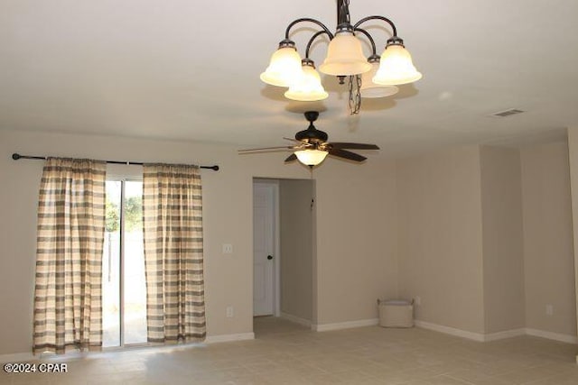 empty room featuring ceiling fan with notable chandelier