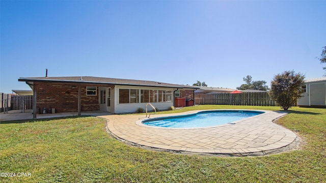 view of swimming pool featuring a patio area and a lawn