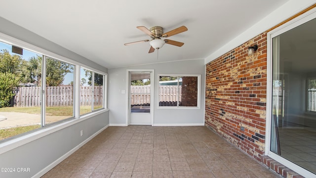 unfurnished sunroom with ceiling fan and lofted ceiling