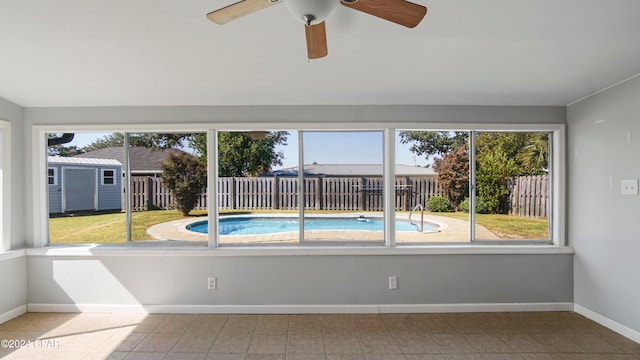 unfurnished sunroom with a healthy amount of sunlight and ceiling fan