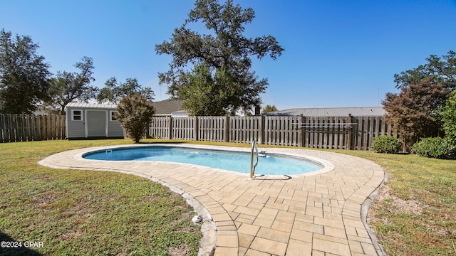 view of pool featuring a patio, a storage shed, and a lawn