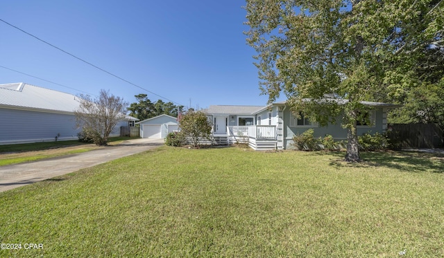 ranch-style home with a porch, an outbuilding, and a front lawn