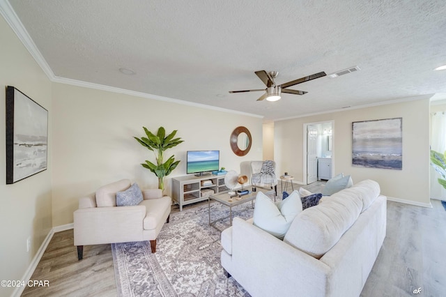 living room featuring a textured ceiling, light hardwood / wood-style floors, ceiling fan, and crown molding