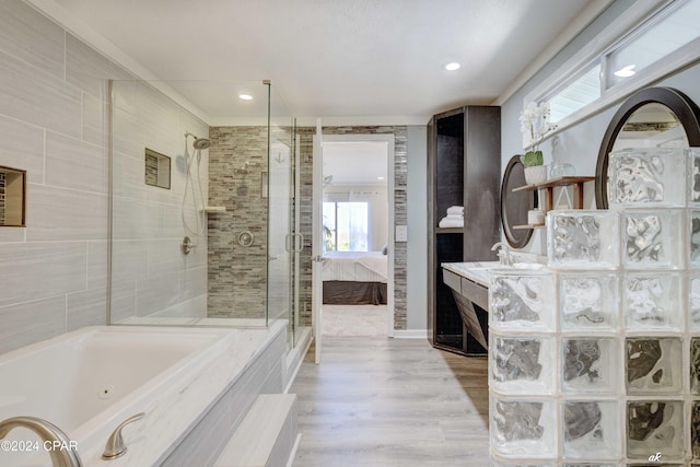 bathroom featuring wood-type flooring, vanity, and separate shower and tub