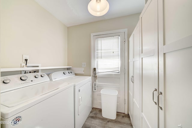 laundry room with washing machine and dryer and light hardwood / wood-style flooring