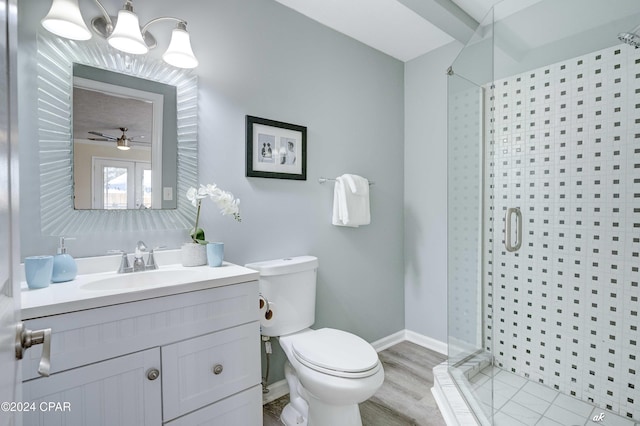 bathroom with hardwood / wood-style floors, vanity, ceiling fan, toilet, and a shower with shower door