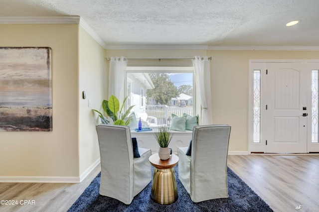 dining room featuring a textured ceiling, wood-type flooring, and crown molding