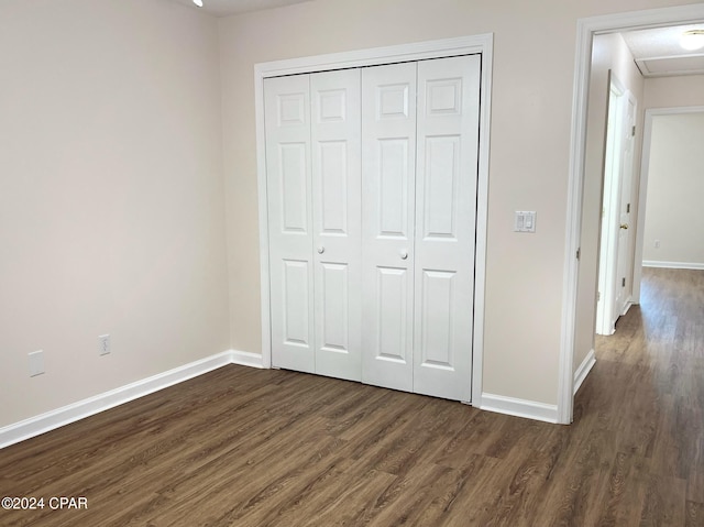 unfurnished bedroom featuring a closet and dark hardwood / wood-style floors